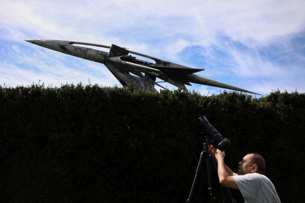 A man tests his camera, ahead of a partial solar eclipse, at New York Hall of Science in Queens borough, New York City, US.