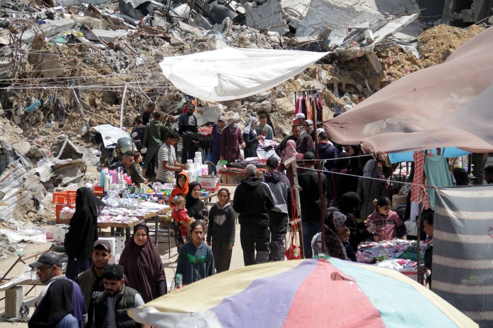 Palestinians shop as they prepare for the upcoming Eid al-Fitr in northern Gaza Strip, on Tuesday. REUTERS