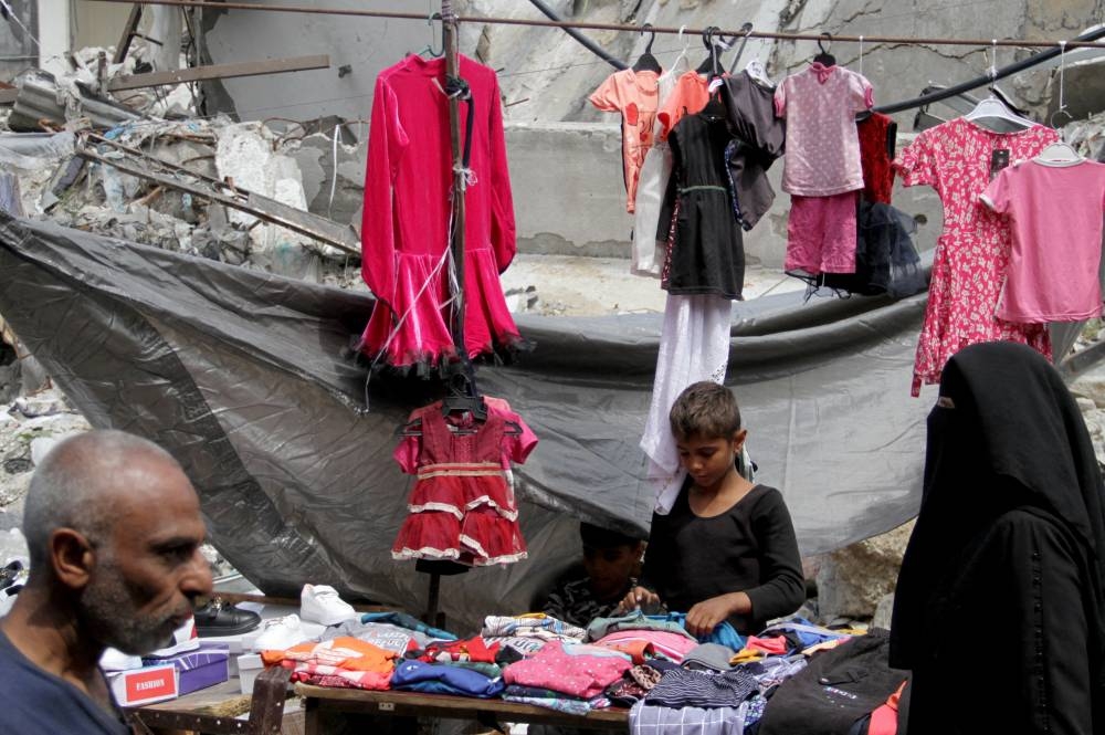 A boy works at a stall as Palestinians shop to prepare for the upcoming Eid al-Fitr in northern Gaza Strip, on Tuesday. REUTERS