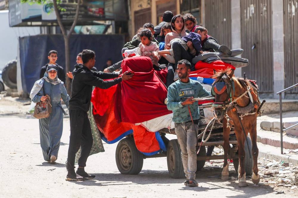 Palestinians leave with their belongings on a horse-cart along a street in Nuseirat, central Gaza, on Friday. AFP