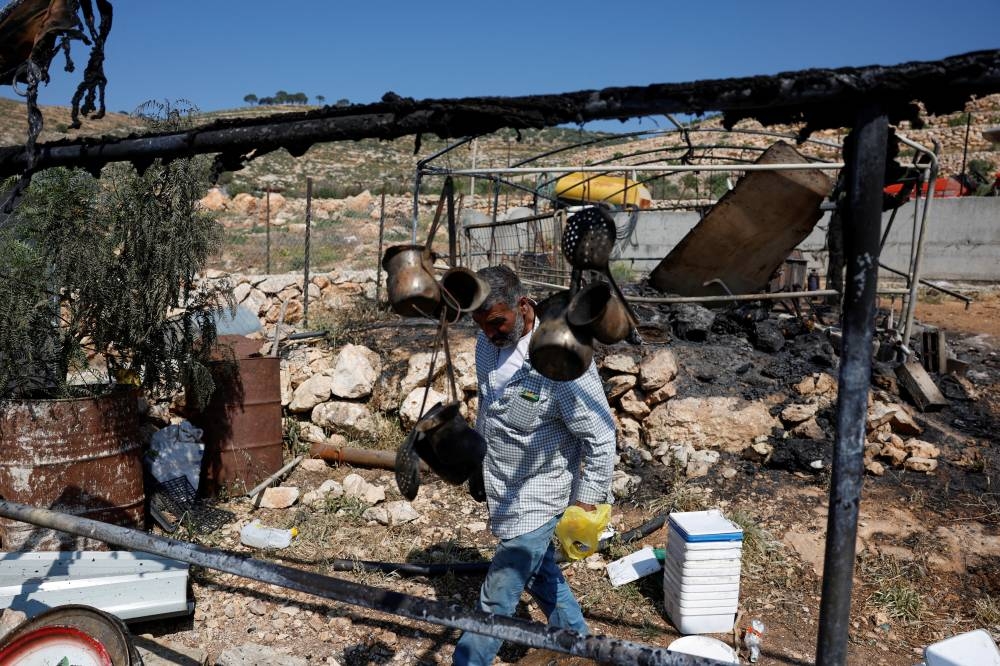A Palestinian man inspects the damage to a house after Israeli settlers attacked the village of al-Mughayyer, in the Israeli-occupied West Bank, on Saturday. REUTERS