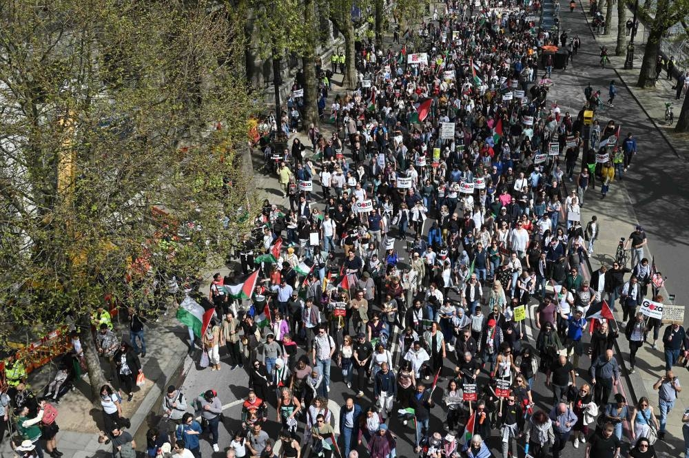 Pro-Palestinian activists and supporters wave flags and hold placards as during a protest march near the the Houses of Parliament in central London, during a National Day of Action calling for a ceasefire in the Israel-Hamas war. AFP