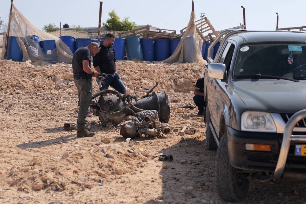 A police officer inspects the remains of a rocket booster that, according to Israeli authorities critically injured a 7-year-old girl, after Iran launched drones and missiles towards Israel, near Arad, Israel, Sunday. REUTERS