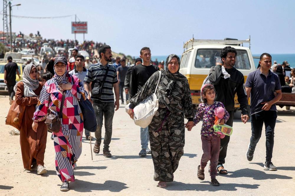 Displaced Palestinians take the coastal Rashid road to return to Gaza City as they pass through Nuseirat in the central Gaza Strip on Sunday. AFP