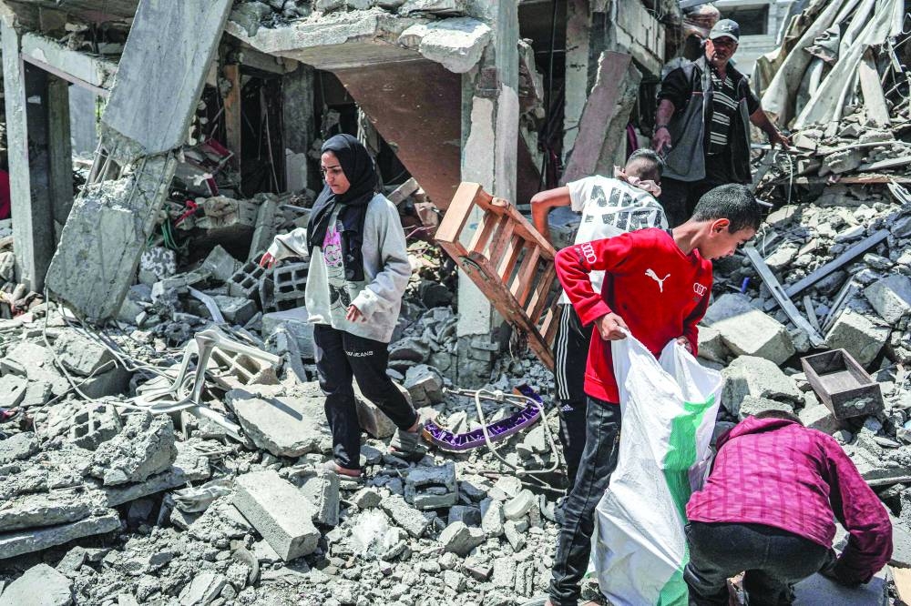 
People search through the rubble of a collapsed building in the eastern side of the Maghazi camp for Palestinian refugees in the central Gaza Strip, yesterday, amid the ongoing conflict between Israel and the Hamas group. 