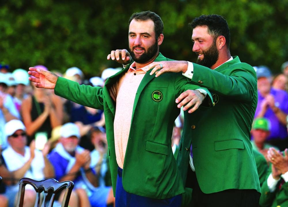 Scottie Scheffler of the US is presented with the green jacket by last year's winner Spain's Jon Rahm after winning The Masters. (Reuters)