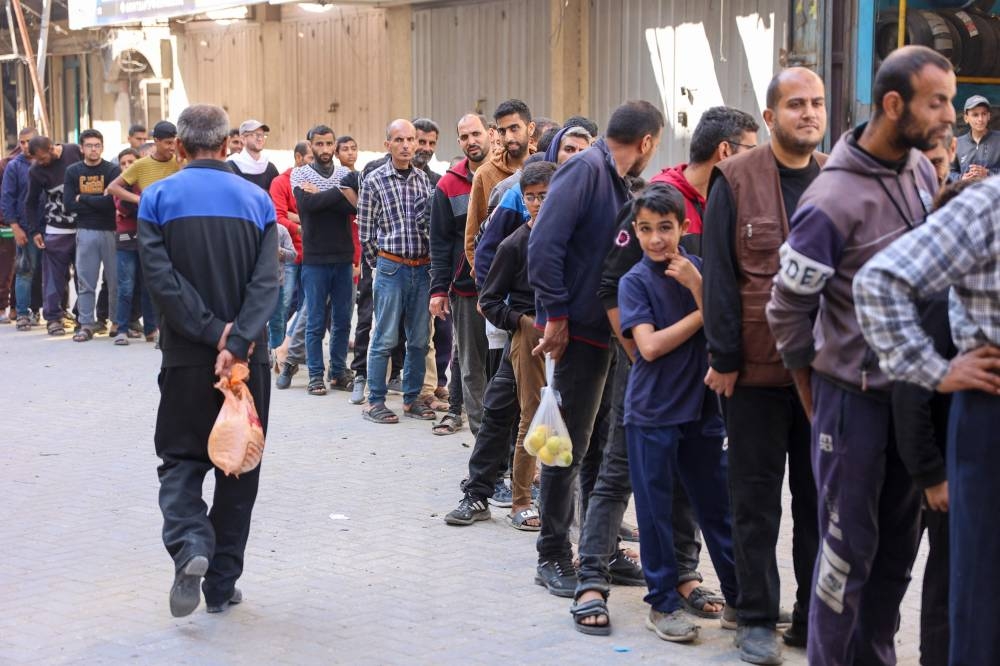 Displaced Palestinians line up to buy subsidised bread from a bakery in Gaza City on Sunday. AFP