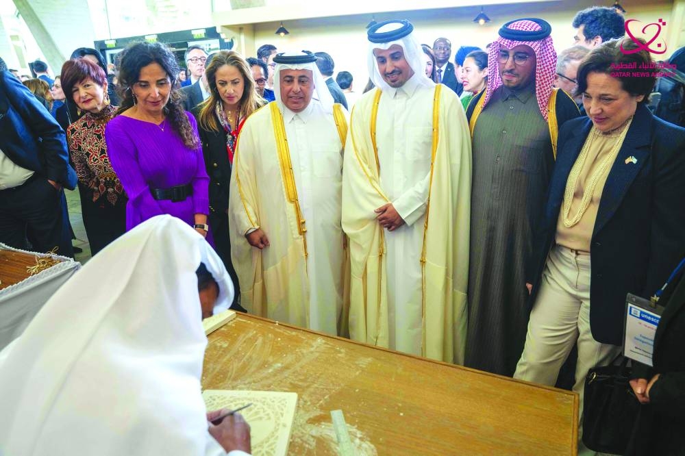 Guests and officials watch a Qatari artist at work during the special celebration organised by Qatar's Ministry of Culture at the Unesco headquarters in Paris.