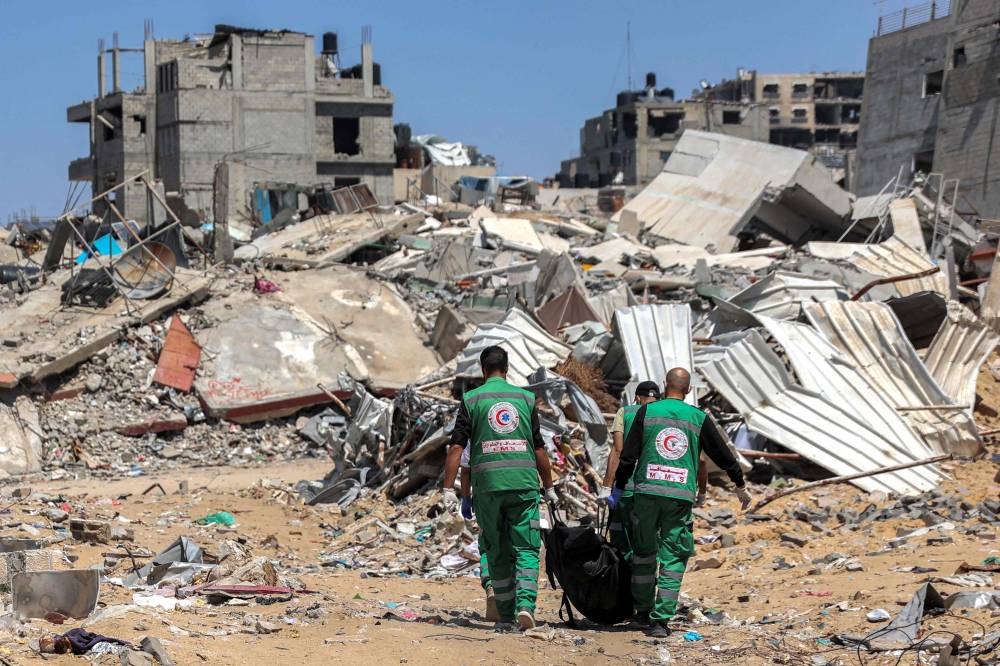 Palestinian paramedics carry away bodies of dead people uncovered in the vicinity of Al-Shifa Hospital in Gaza City on Wednesday after the recent Israeli military operation there. AFP