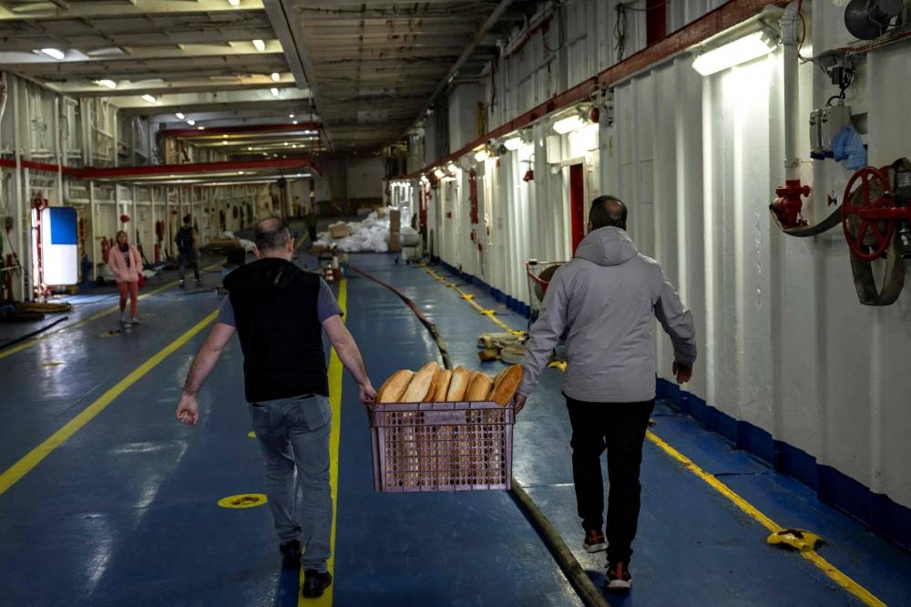 Bread is carried on board as workers prepare a ship from the Freedom Flotilla Coalition while it anchors in the Tuzla seaport, in Istanbul on Friday. AFP
