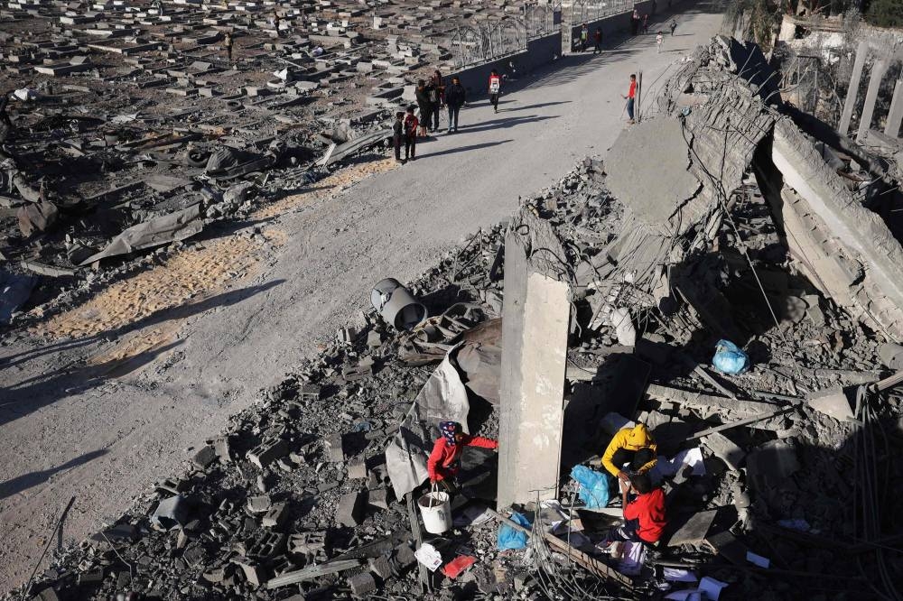 Palestinians salvage belongings from the rubble of a house hit by overnight Israeli bombing in Rafah in the southern Gaza Strip on Saturday. AFP