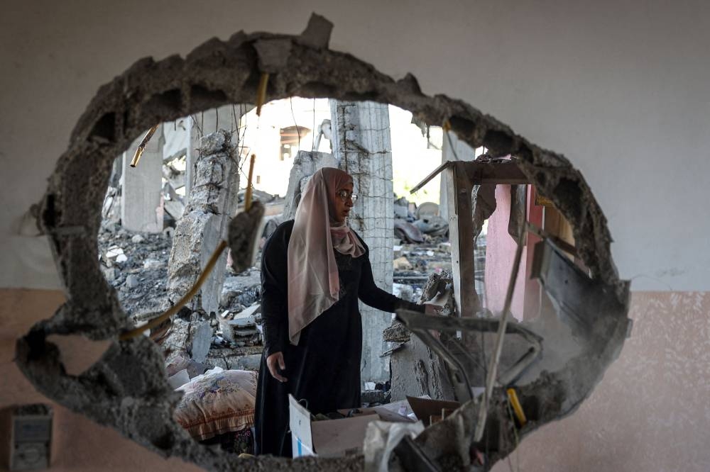 A Palestinian woman checks the rubble of a home hit by overnight Israeli bombing in Rafah in the southern Gaza Strip on Saturday. AFP