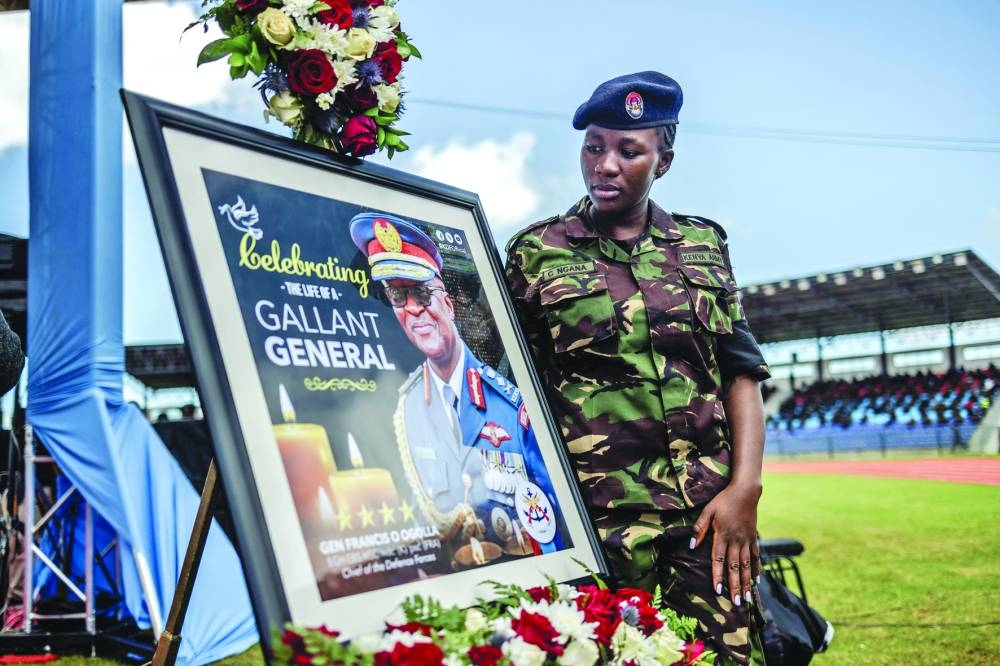 
A member of the Kenyan army with a picture depicting General Francis Omondi Ogolla. 