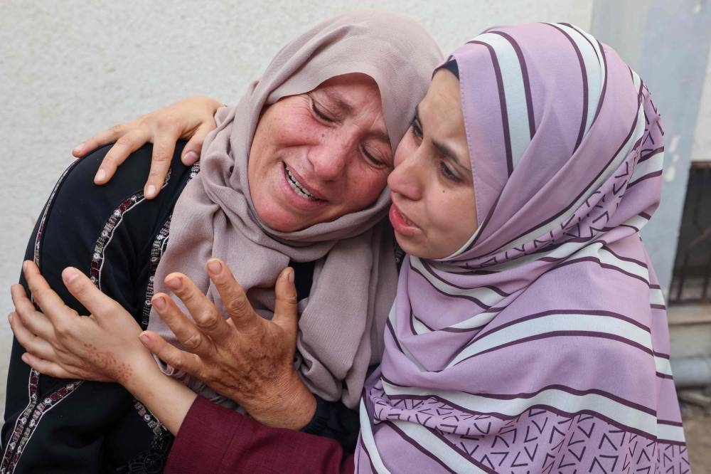 Palestinians grieving over the bodies of relatives killed in Israeli bombardment, at the al-Najar hospital in Rafah, in the southern Gaza Strip, Sunday. AFP