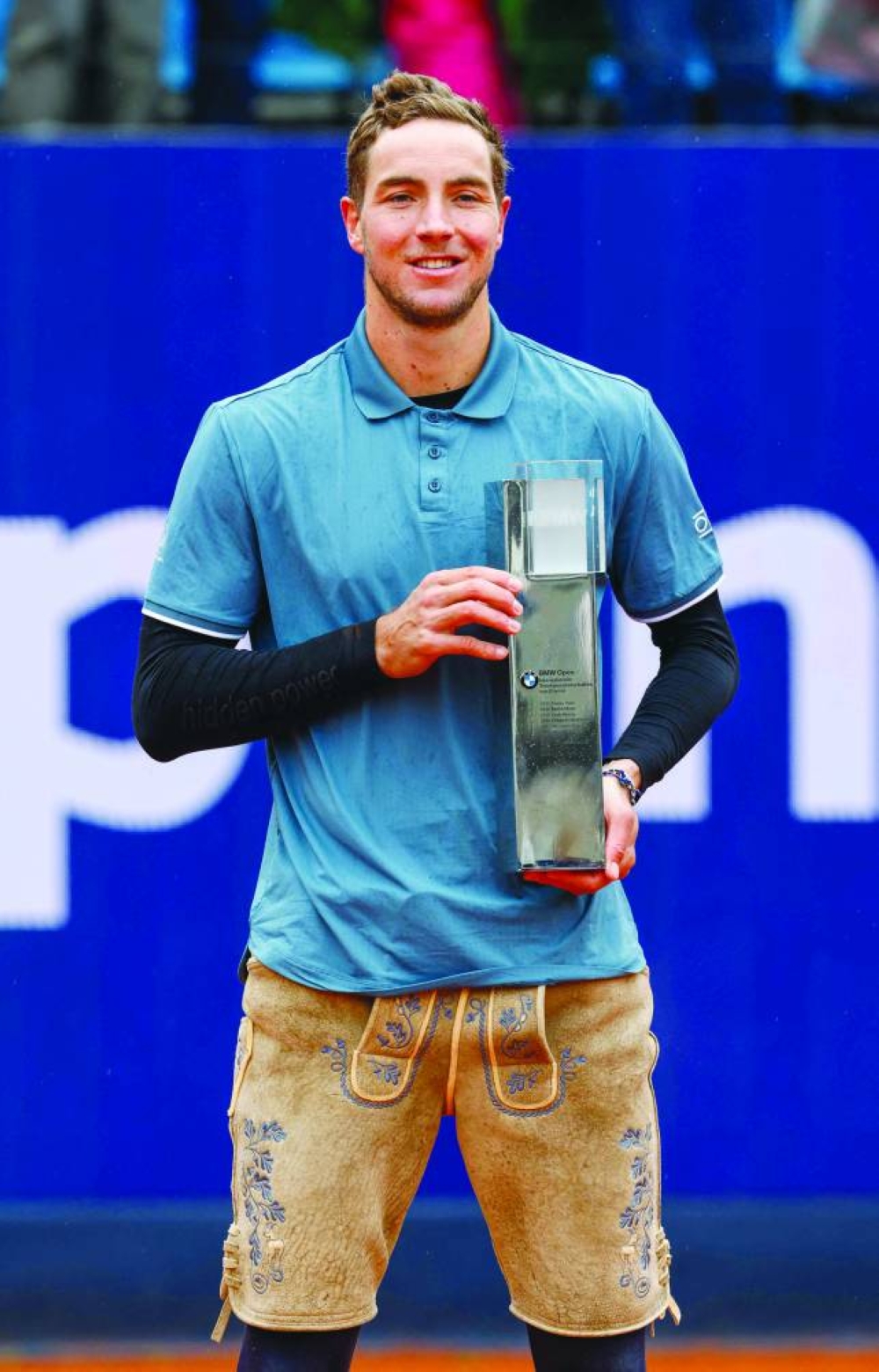 Germany's Jan-Lennard Struff wears traditional "Lederhosen" (leather trousers) dress and presents his trophy after defeating Taylor Fritz from the US (not in picture) in the final of the ATP Tour tennis tournament in Munich, southern Germany, yesterday. (AFP)
