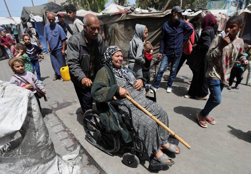 Displaced Palestinians, who fled their homes due to Israeli strikes, shelter in a UNRWA-affiliated school in Deir Al-Balah, in the central Gaza Strip Wednesday. REUTERS