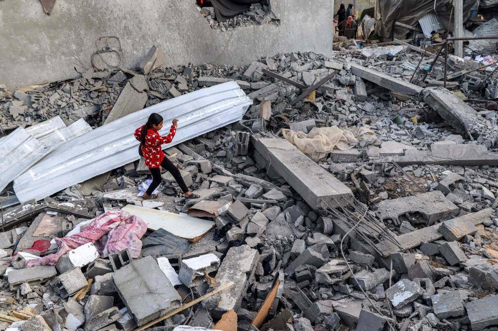 A girl walks through rubble in Rafah in the southern Gaza Strip on Wednesday. AFP
