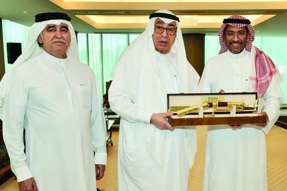 QBA first deputy to the chairman, Hussain Ibrahim Alfardan, handing over a token of recognition to Saudi Arabia’s Minister of Industry and Mineral Resources, Bandar bin Ibrahim al-Khorayef, while QBA board member Sheikh Nawaf Nasser bin Nasser al-Thani looks on.