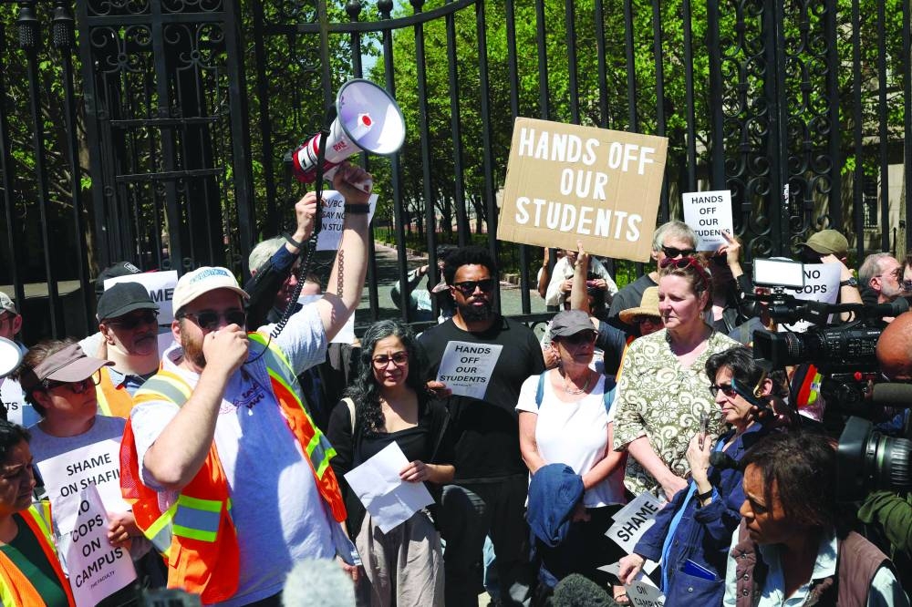 
Pro-Palestinian student protesters lock arms at the entrance to Hamilton Hall on the campus of Columbia University, in New York City. Below: Teachers protest outside of Columbia University in New York City, yesterday. 