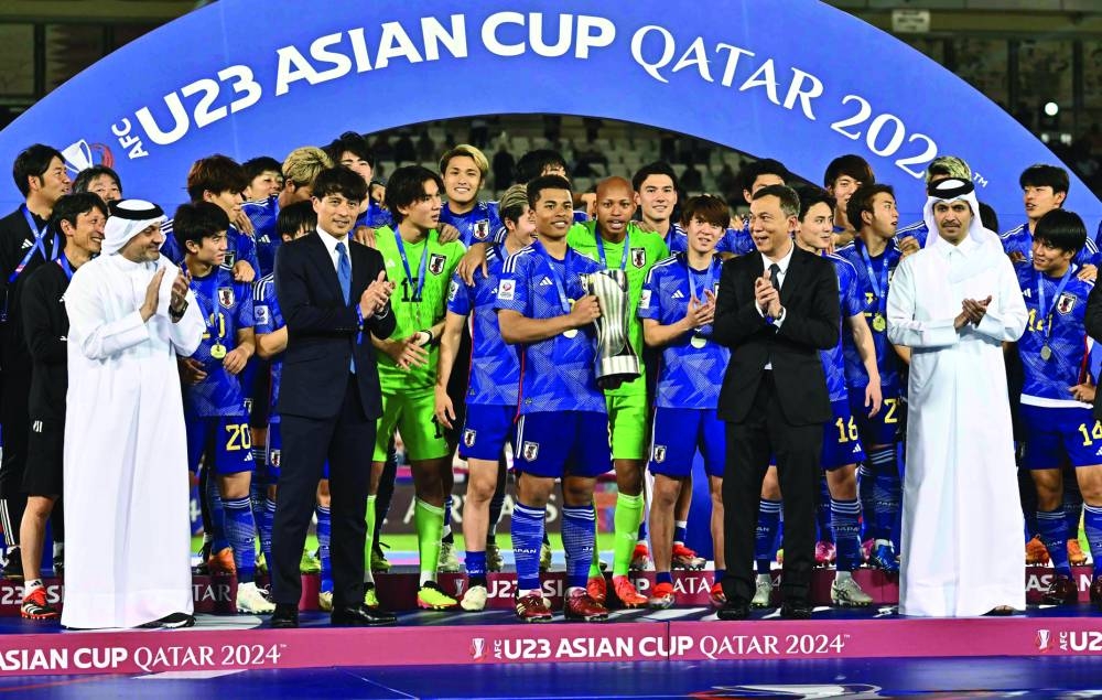 
Qatar Football Association President Jassim bin Rashid al-Buenain and Qatar Stars League CEO Hani Taleb Ballan pose with Japan captain Joel Chima Fujita, who was named Most Valuable Player of the Asian Cup U-23 Qatar. 