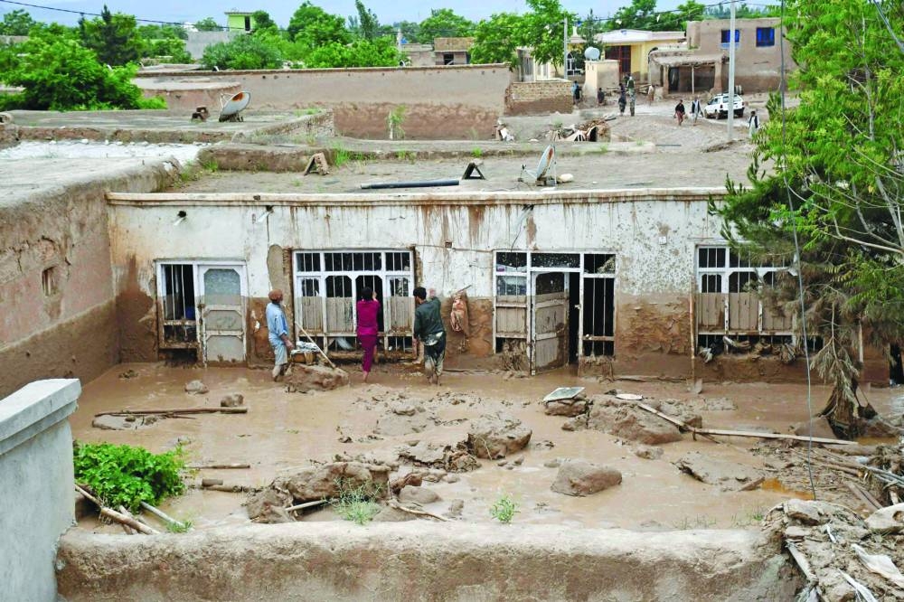 Afghan men clear mud from a house following flash floods after heavy rainfall at a village in Baghlan-e-Markazi district of Baghlan province, yesterday.