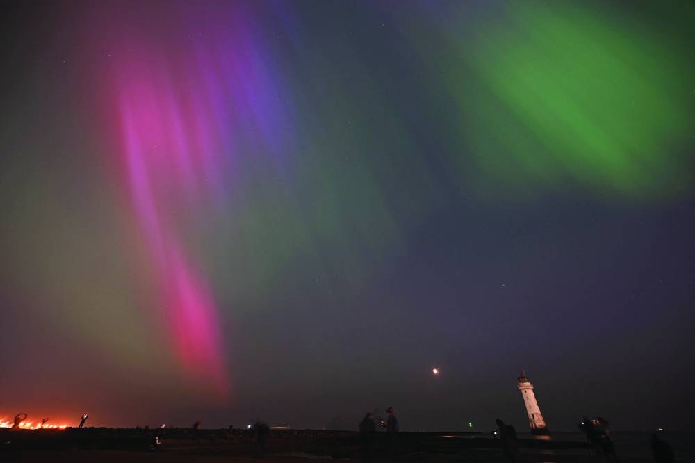
People gather to watch the Aurora Borealis, also known as the Northern Lights, in New Brighton in northwest England. 