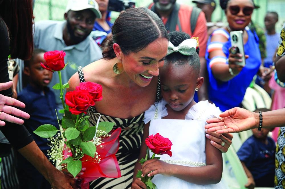Meghan receiving flowers at a volleyball match played with wounded army veterans, at the Nigerian army officers' mess in Abuja.