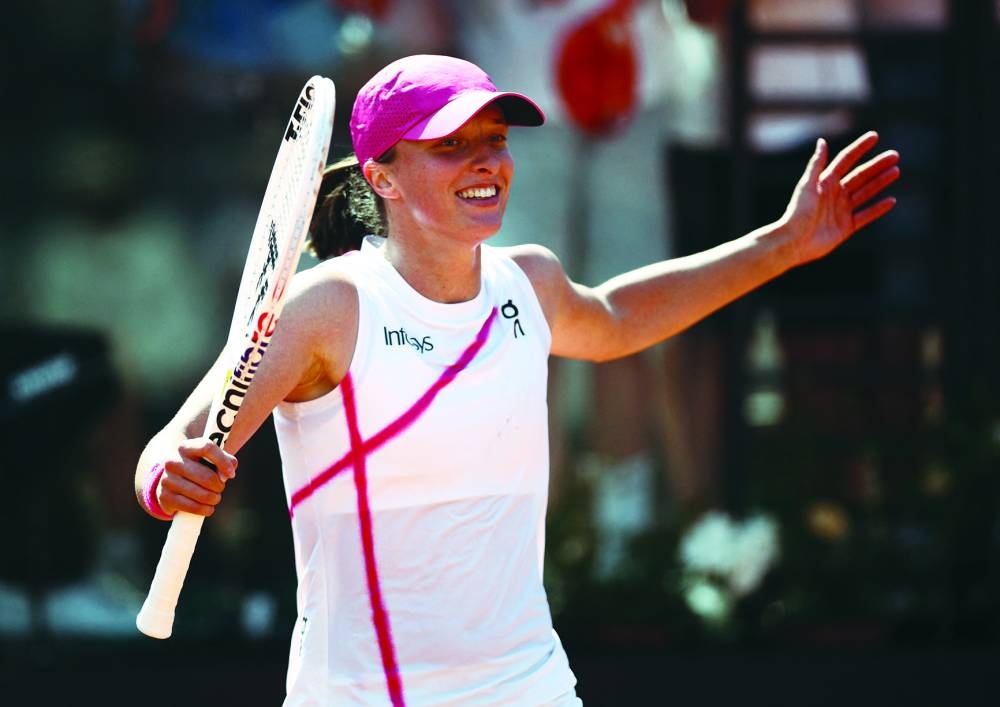Poland’s Iga Swiatek celebrates after winning her quarter-final against Madison Keys of the US at the Italian Open in Rome on Tuesday. Right: Tommy Paul (right) of the US shakes hands with Russia’s Daniil Medvedev after winning their round of 16 match at the Italian Open in Rome on Tuesday. (Reuters)