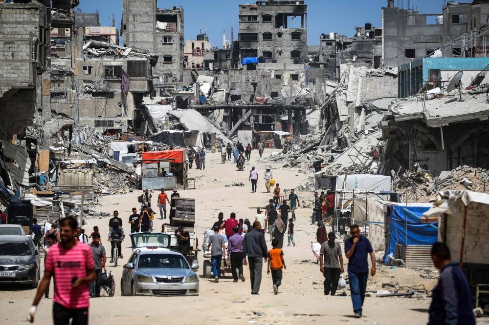 Displaced Palestinian walk along a devastated street in Khan Yunis in the southern Gaza Strip, on Saturday. AFP
