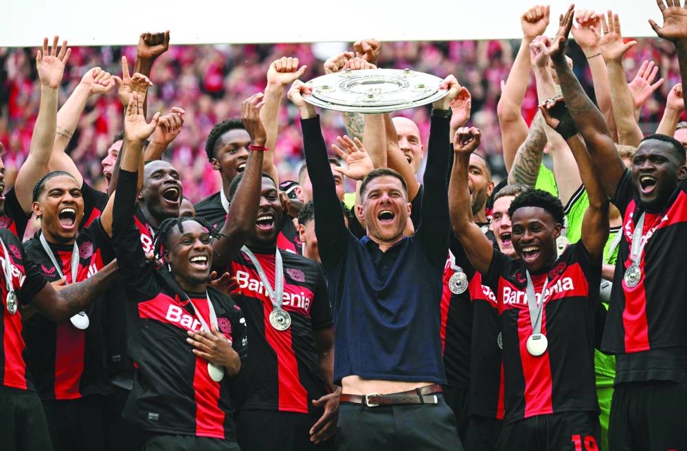 Bayer Leverkusen’s head coach Xabi Alonso and his players celebrate with the Bundesliga trophy on Saturday. (AFP)