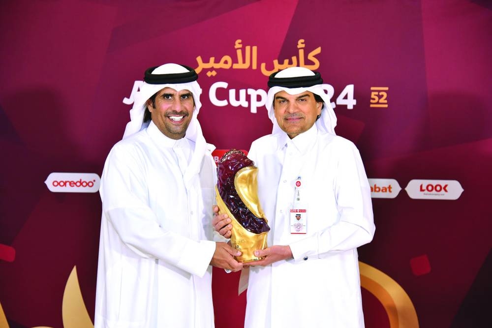 
QIIB chief executive officer Dr Abdulbasit Ahmed al-Shaibei and Qatar Football Association’s director of Marketing and Communications Khaled al-Kuwari pose with the Amir Cup trophy. 