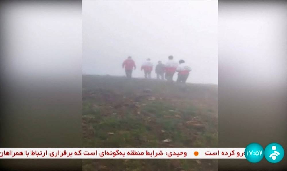 This grab taken from handout video footage released by the IRINN Iranian state television network on May 19, 2024 shows rescuers heading towards the site of the "accident" involving a helicopter in the convoy of Iran's President in the Jofa region of the western province of East Azerbaijan. 