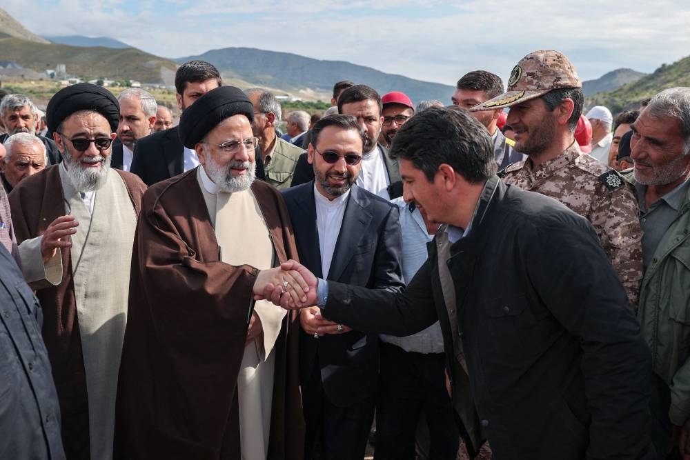 A handout picture provided by the Iranian presidency shows Iran's President Ebrahim Raisi (2nd L) with members of his delegation in Aras, ahead of the inauguration ceremony for a dam project on the border between the two countries, on May 19, 2024. A helicopter in the convoy of the Iranian president was involved in "an accident" in East Azerbaijan province on May 19, state televsion reported, without specifying if the president was on board. (Photo by Iranian Presidency / AFP) / === RESTRICTED TO EDITORIAL USE - MANDATORY CREDIT "AFP PHOTO / HO / IRANIAN PRESIDENCY" - NO MARKETING NO ADVERTISING CAMPAIGNS - DISTRIBUTED AS A SERVICE TO CLIENTS ===