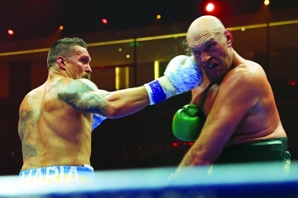Ukraine’s Oleksandr Usyk (left) lands a punch against Britain’s Tyson Fury during a heavyweight boxing world championship fight at Kingdom Arena in Riyadh, Saudi Arabia, on Sunday. Usyk beat Fury by split decision to win the world’s first undisputed heavyweight championship in 25 years, an unprecedented feat in boxing’s four-belt era.  (AFP)