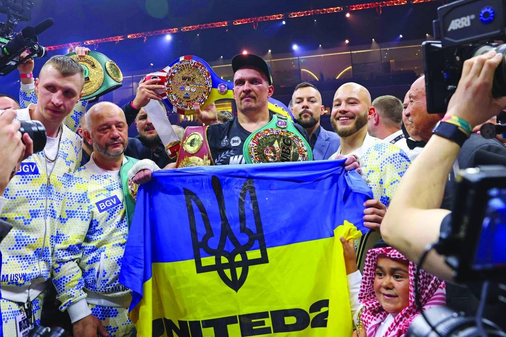 Ukraine's Oleksandr Usyk (centre) celebrates his victory over Britain's Tyson Fury during a heavyweight boxing world championship fight at Kingdom Arena in Riyadh, Saudi Arabia, on Sunday. (AFP)