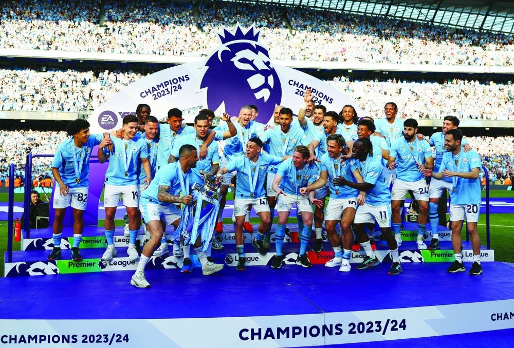 Manchester City’s players celebrate with the trophy after winning the Premier League in Manchester on Sunday. (Reuters)