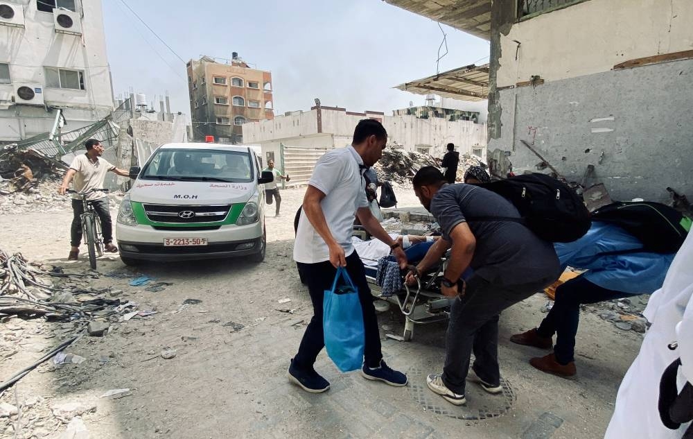 Palestinians evacuate Kamal Adwan hospital following an Israeli strike in Beit Lahia in the northern Gaza Strip, on Tuesday. REUTERS