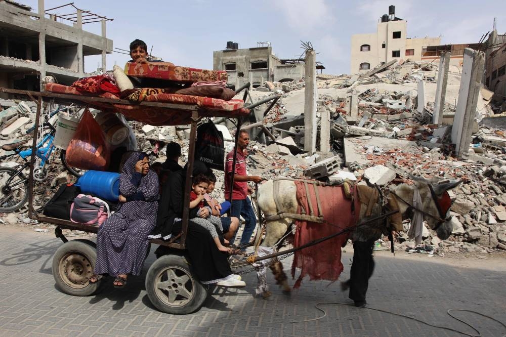 A Palestinian family relocates with their belongings in Beit Lahia, in the northern Gaza Strip on Sunday. AFP