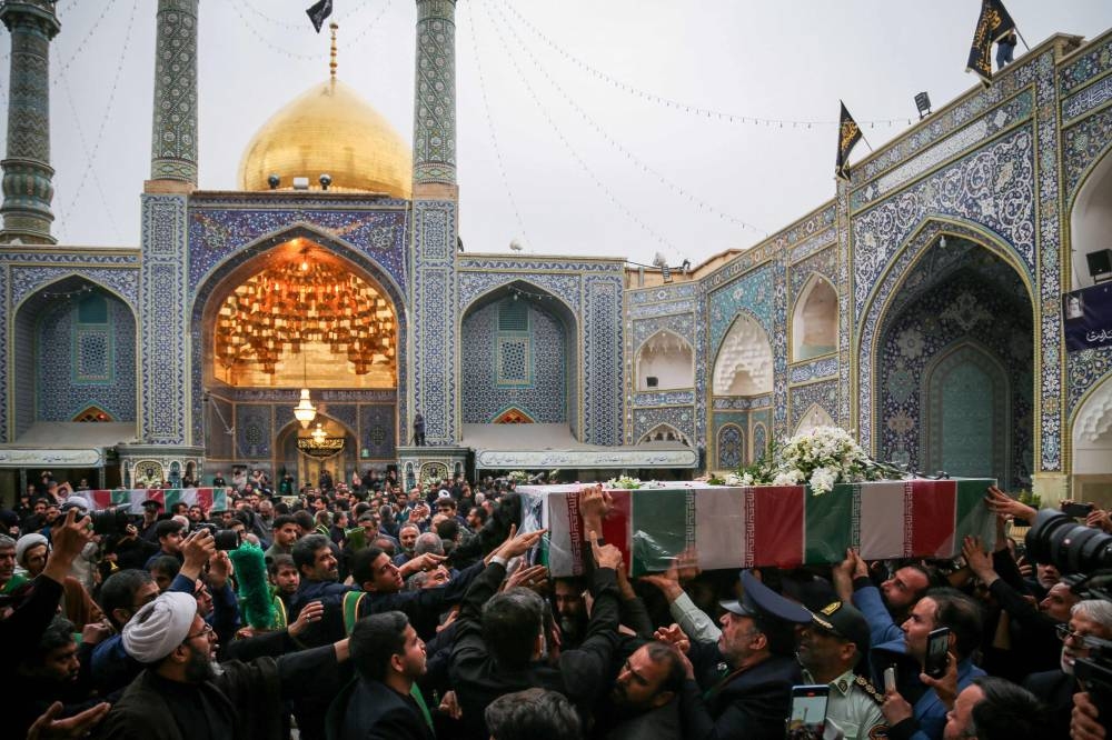 Mourners attend the funeral procession of Iran's President Ebrahim Raisi at a Muslim Shiite Shrine in Qom, on Tuesday.