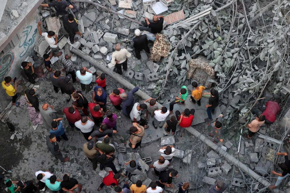 Palestinians search for survivors at the site of an Israeli strike on the Al-Daraj neighbourhood in Gaza City, on Friday. AFP
