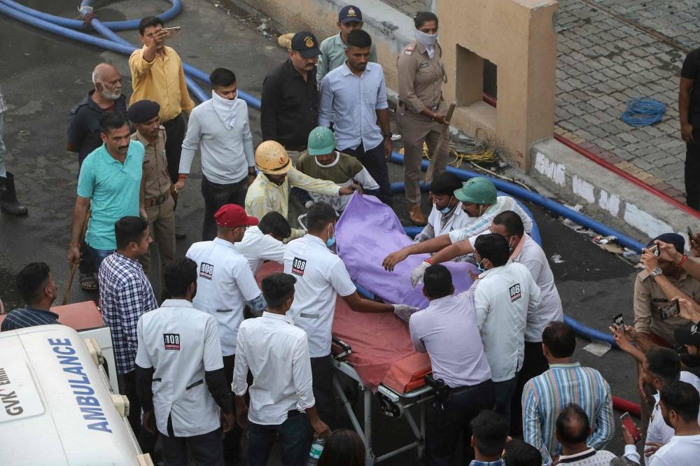 Rescue workers transport a victim on a stretcher after a fire broke out at an amusement park facility in Rajkot, in India's Gujarat state on Saturday. AFP