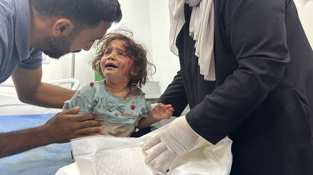 A Palestinian child, wounded in an Israeli strike on an area designated for displaced people, is assisted at a hospital in Rafah in the southern Gaza Strip, on Sunday. REUTERS