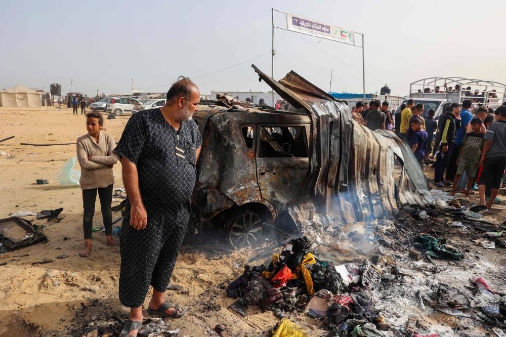 Palestinians gather at the site of an Israeli strike on a camp area housing internally displaced people in Rafah on Monday. AFP