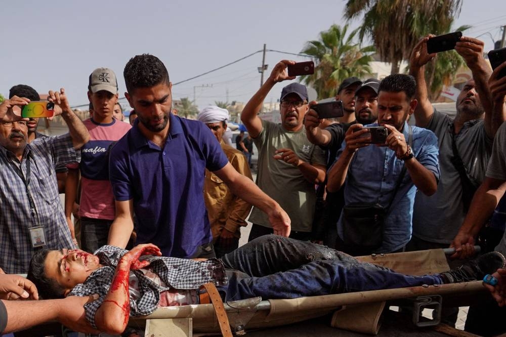 People transport casualties of Israeli bombardment on Nuseirat city and east of Deir al-Balah, at the Al-Aqsa Martyrs Hospital in the central Gaza Strip on Monday. AFP