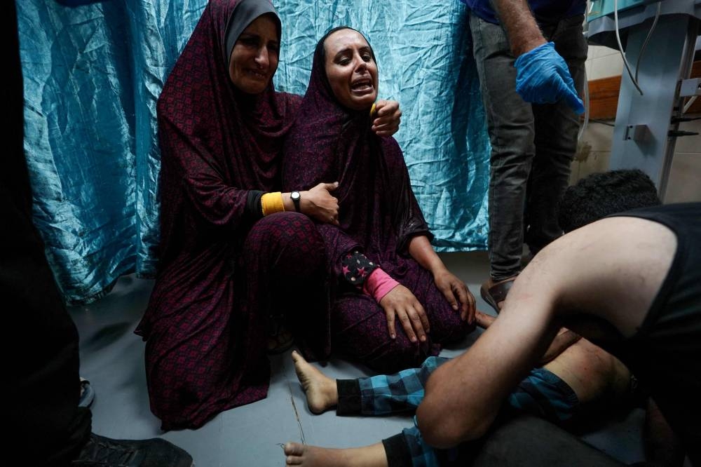 The mother (C) of Palestinian boy Khaled Abu Samaha reacts after her son was rushed to the Al-Aqsa Martyrs Hospital in the central Gaza Strip following his injury in Israeli bombardment on a house in Nuseirat city on Monday. AFP