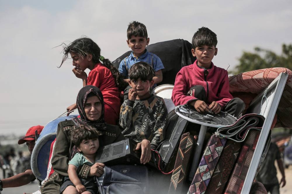 Palestinians fleeing with their belongings ride atop their vehicle in Rafah in the southern Gaza Strip on Wednesday. AFP