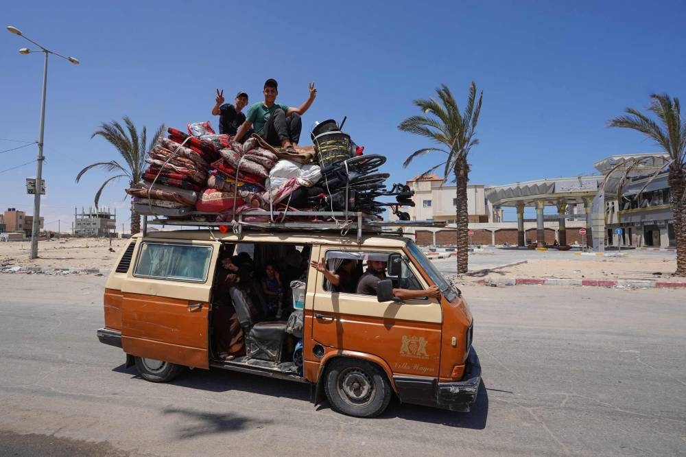 Palestinians fleeing with their belongings drive their vehicle in Rafah in the southern Gaza Strip, Wednesday.