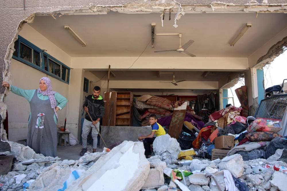 Palestinians salvage belongings from a damaged UN-run school in the Jabalia refugee camp in the northern Gaza Strip after they returned briefly with others to check on their homes on Friday. AFP