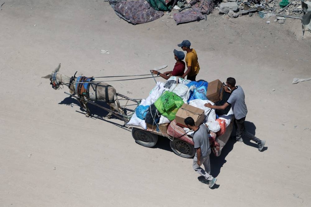 Palestinians transport some salvaged belongings as they leave the Jabalia refugee camp in the northern Gaza Strip after they returned briefly to check on their homes on Friday. AFP
