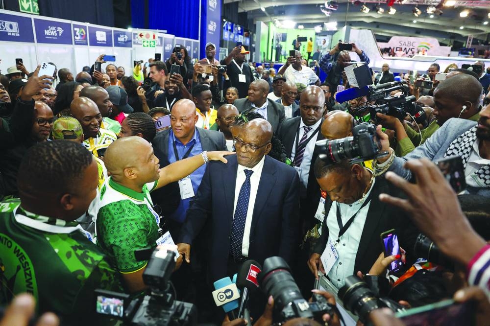 Former South African President and uMkhonto weSizwe Party leader Jacob Zuma (centre) is greeted by party members as he arrives at the Independent Electoral Commission National Results Center in Midrand, on Saturday.
